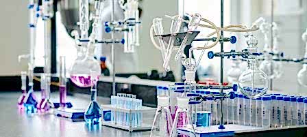Two empty beakers standing next to glassware equipment for chemical experiments on workplace of biotechnologist or scientist